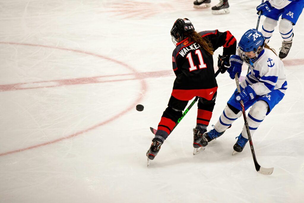 Two young hockey players battling for the puck.